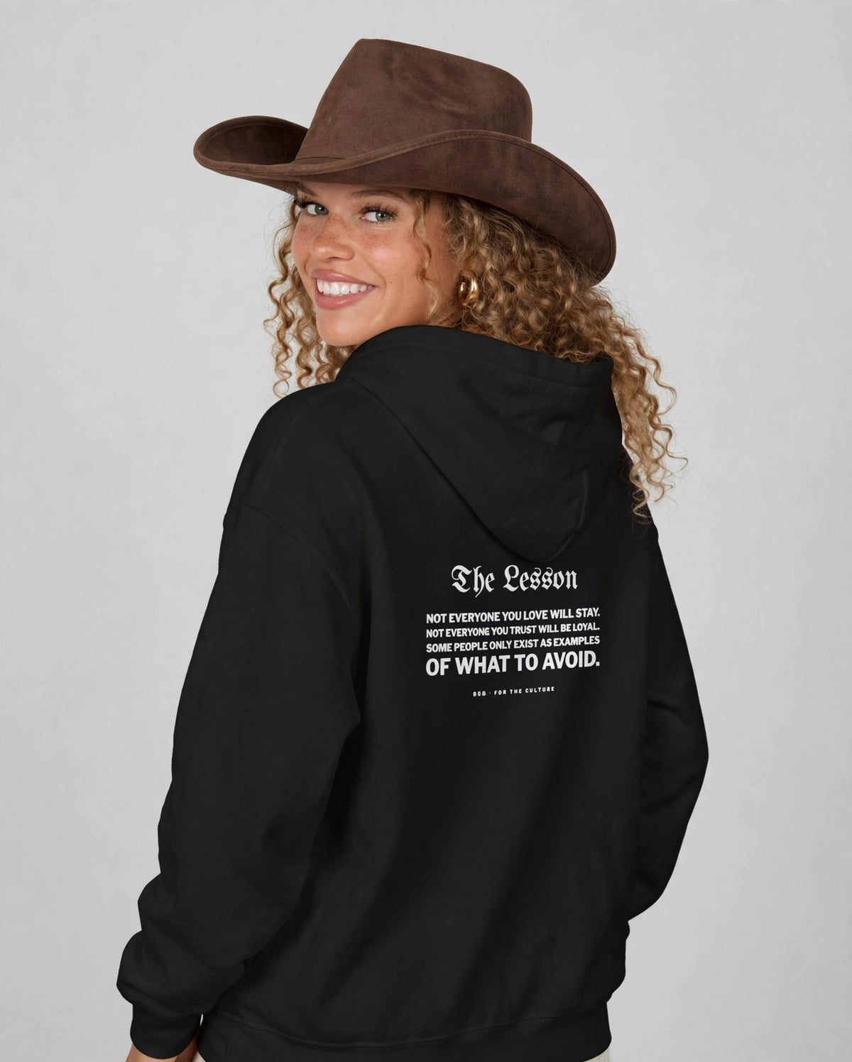 Amara wearing the The Lesson Hoodie – Blackletter (Black), back view