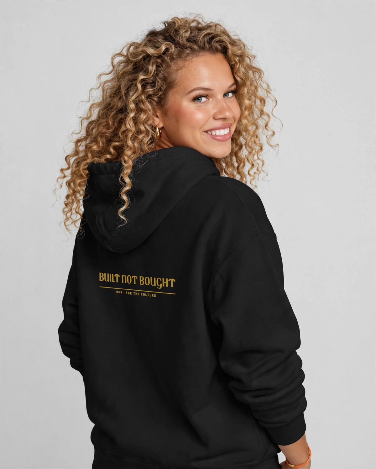 Amara wearing the Built Not Bought Hoodie – Trochut (Black), back view
